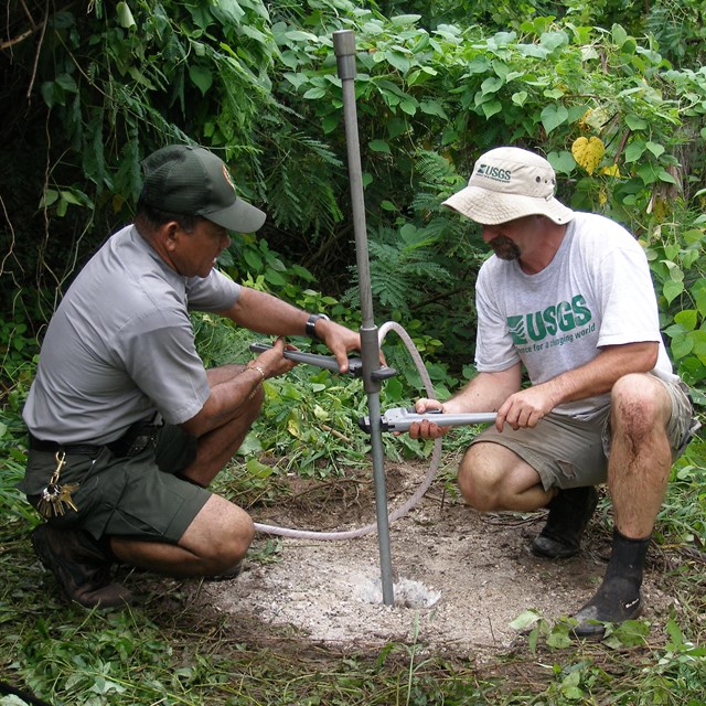 NPS staff and USGS partner assessing groundwater well at American Memorial Park