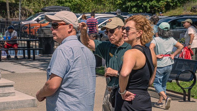 A Volunteer in Parks provides information to two visitors