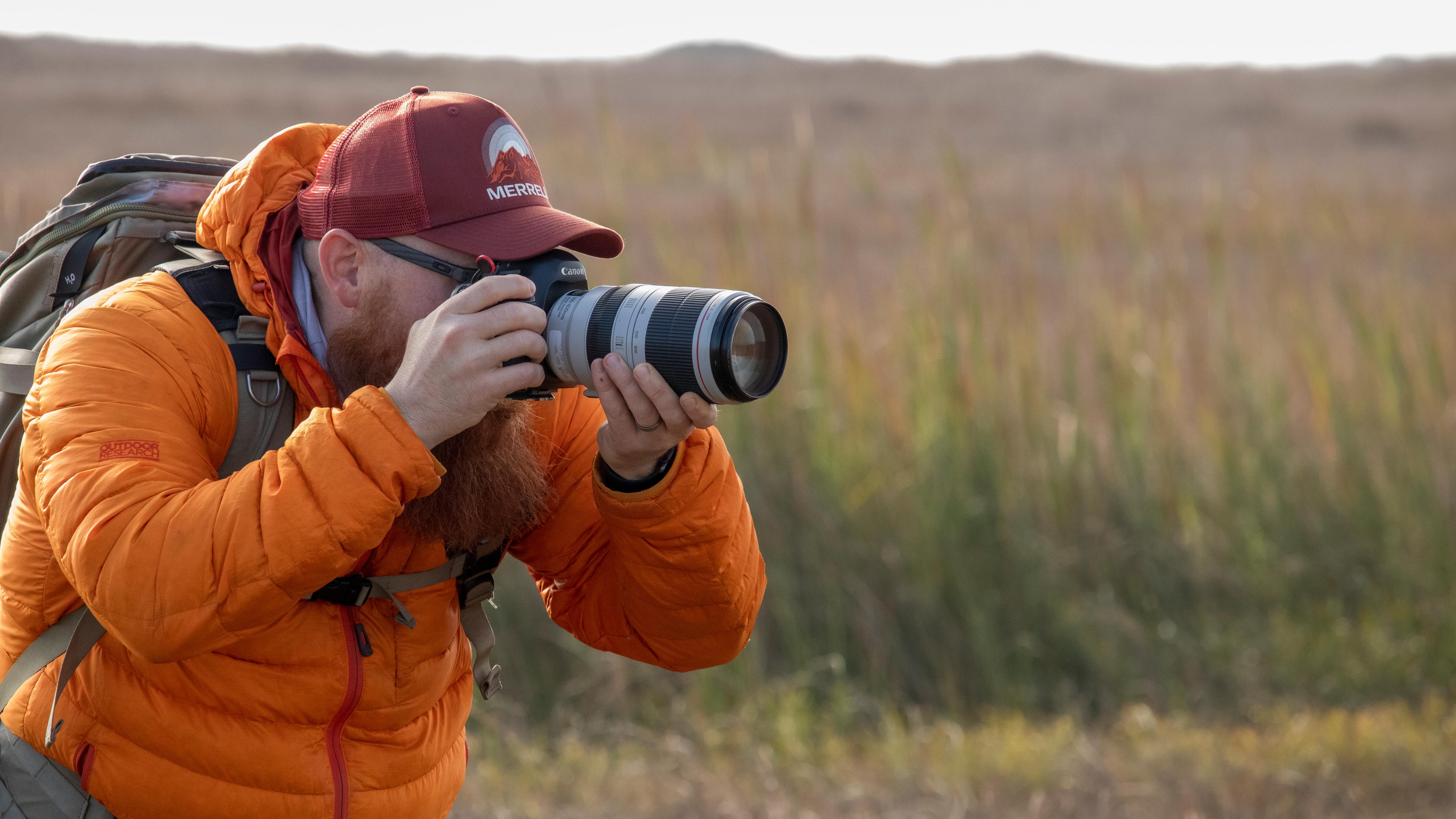 A person using a camera with a large lens to take a photo.