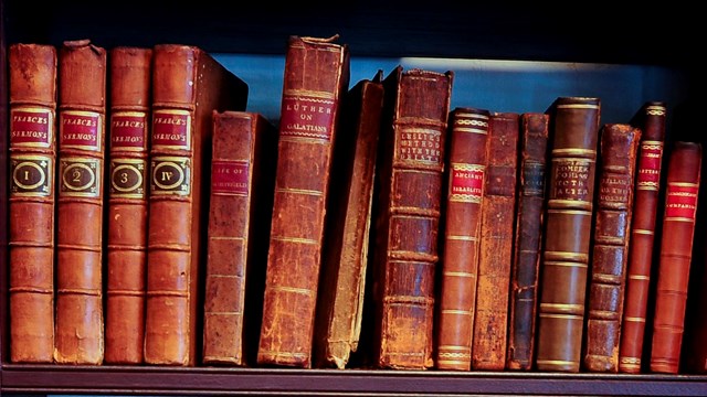 A color photo of showing some of the original books in Bishop White's study.