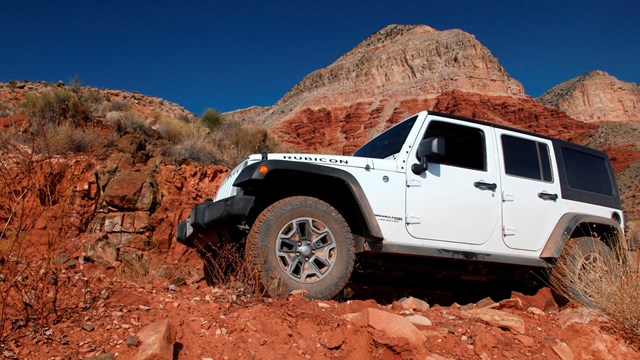 Jeep on steep road by dropoff