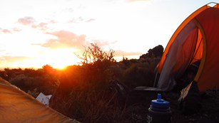 A backpacker enjoys twilight in the wilderness overlooking the Painted Desert
