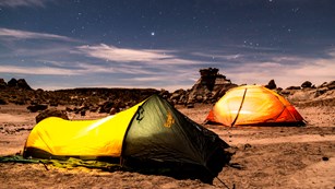 A backpacker enjoys twilight in the wilderness overlooking the Painted Desert