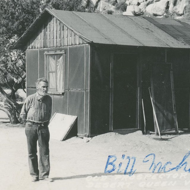 Bill McHaney in front of cabin