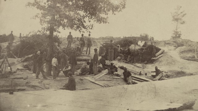 30 men standing around tents and bombproofs