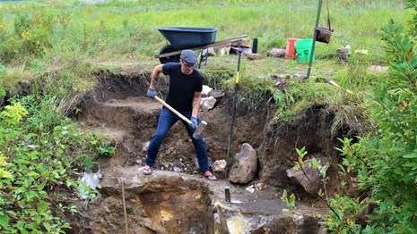 A man in a quarry with a sledgehammer