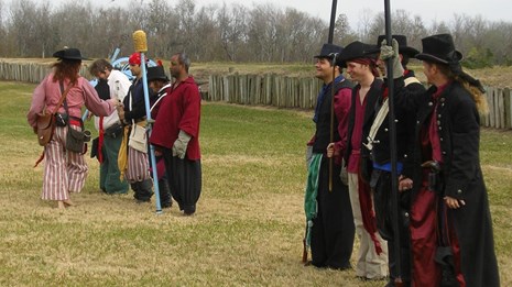 People in various uniforms stand in a row