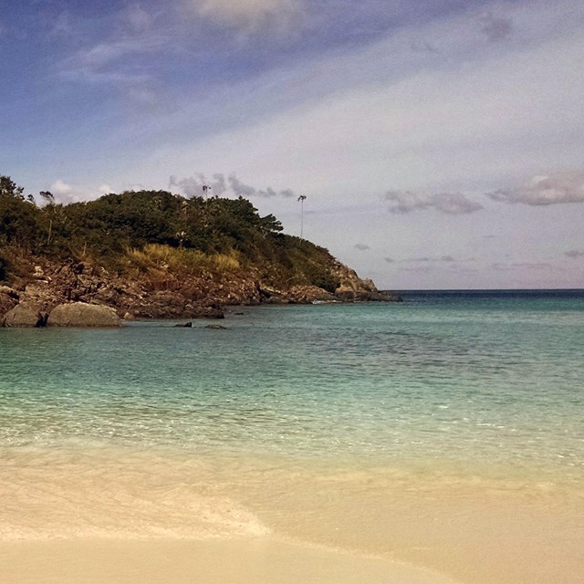 a coastal beach with small island in center
