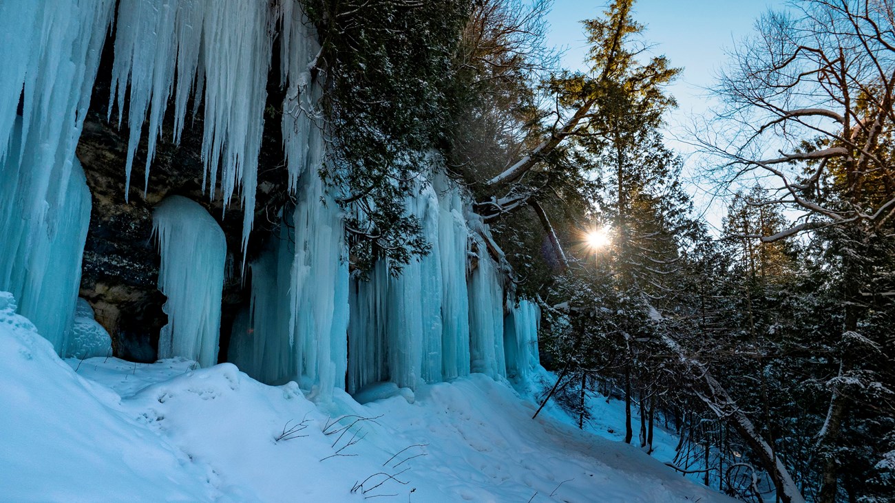 Large blue icicles ooze from a sandstone cliff