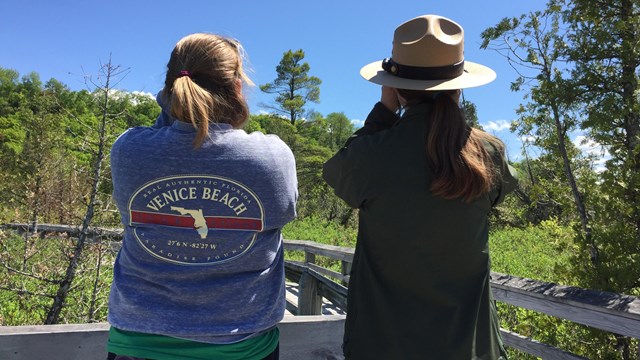 Park ranger and visitor with binoculars