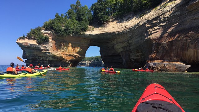 Kayaks paddling near Lover's Leap, a rock formation along lakeshore's coastline
