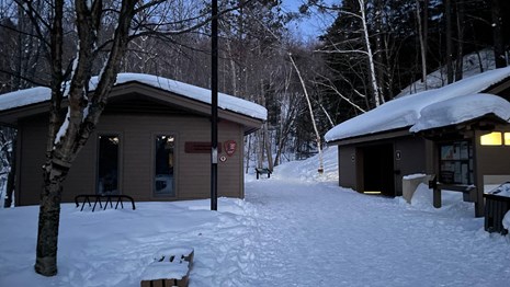 Snow covers the grounds around the Munising Falls Visitor Center