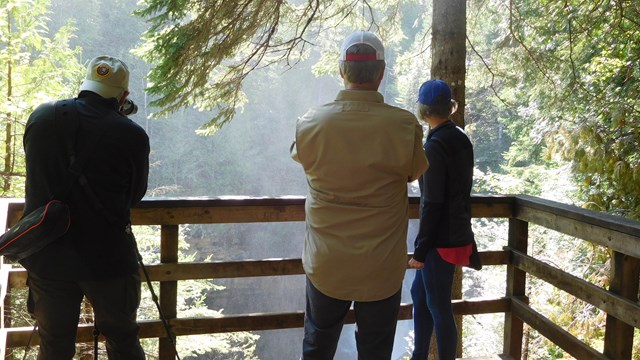 A group of three people on an overlook.