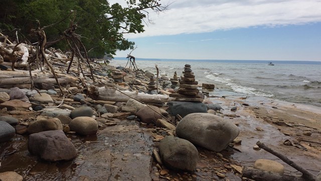 A few stacks of rocks and driftwood staged on the beach.