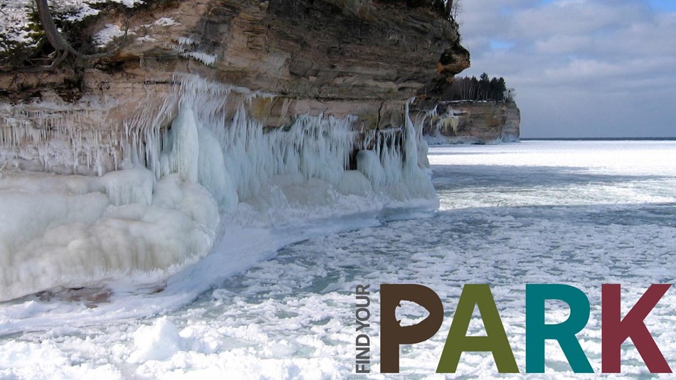Ice clings to sandstone cliffs and forms the surface of Lake Superior