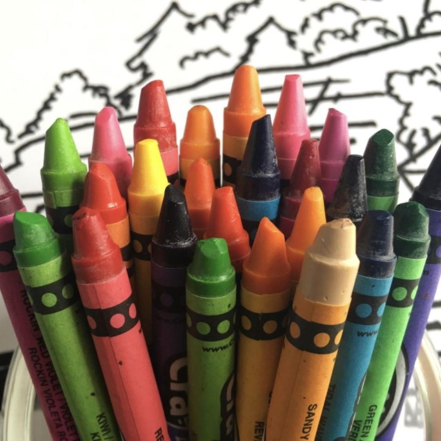 Coloring page of the Pictured Rocks cliffs colored in with crayons laying on top of it.