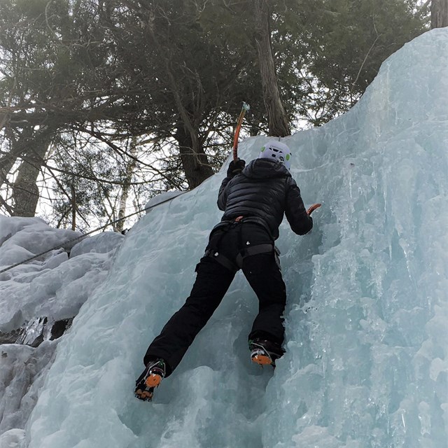 Visitor ice climbing on the ice formations within Pictured Rocks National Lakeshore