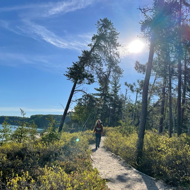 A hiker on a trail above a Lake Superior beach