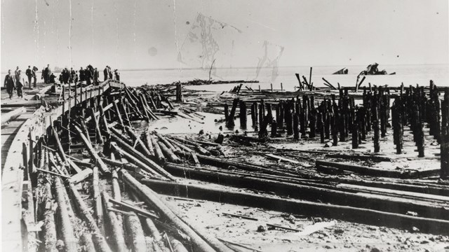 An historic photo of the disaster. Piles of wood from the pier can be seen. 