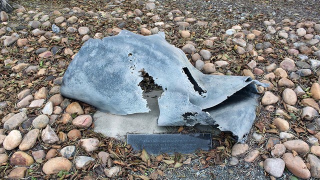 A small piece of ship metal debris is installed in the ground, as an exhibit. 