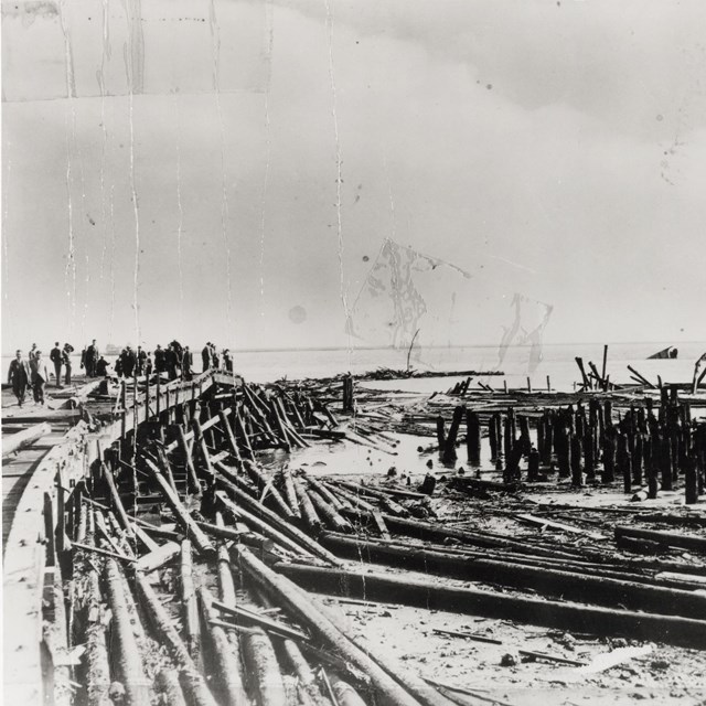 An historic photo of the disaster. Piles of wood from the pier can be seen. 
