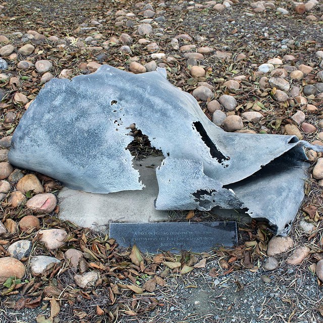 A small piece of ship metal debris is installed in the ground, as an exhibit. 