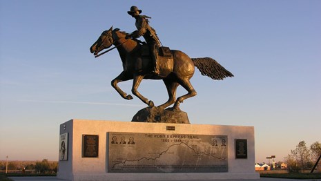 A large metal statue of a man riding a horse.