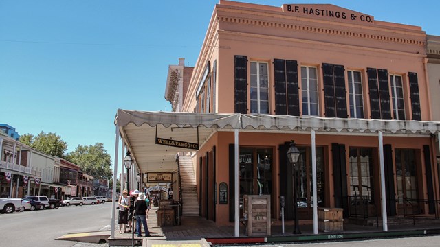 A two story historic building with a covered walk way on the first floor.