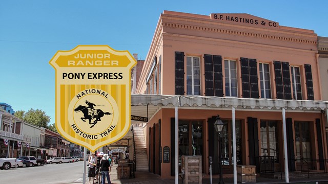 A two story building, with a wrap around porch, with an image of a shield junior ranger badge.