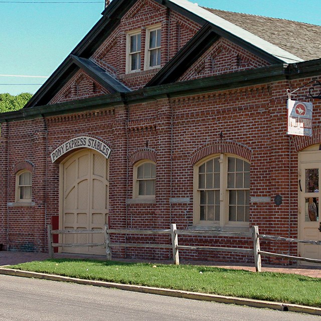 A large red brick building with a large stable door.