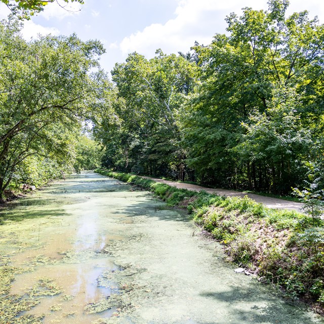 A canal filled with water next to a path