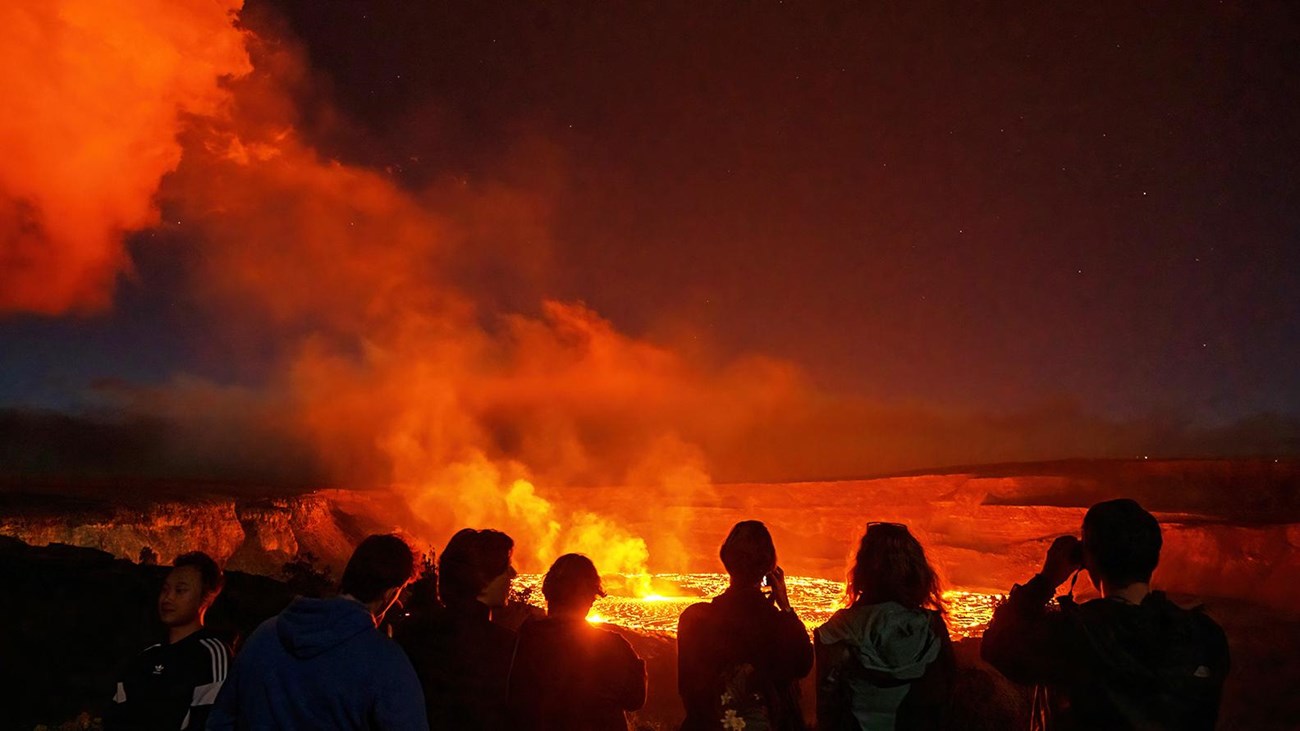 Group of visitors viewing nighttime eruption of Kilauea