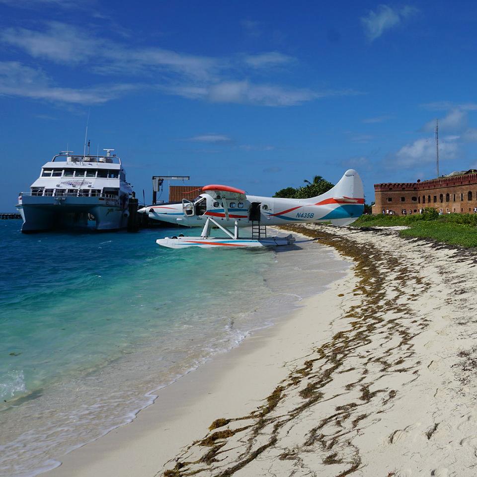 Ferry at dock and sea plane on sandy beach outside Fort Jefferson, Dry Tortugas National Park