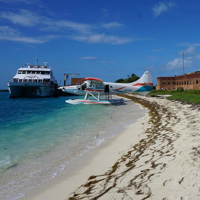 Ferry at dock and sea plane on sandy beach outside Fort Jefferson, Dry Tortugas National Park