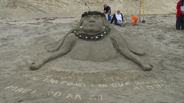 A sand sculpture of the head and upper torso of a Hawai'ian woman wearing a flower crown.