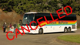 Visitors board a Marin Airporter bus at Drakes Beach. A red
