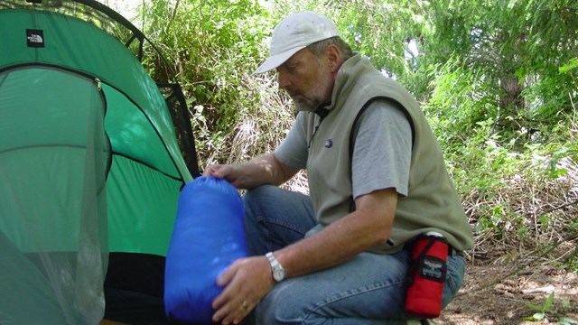 A camper setting up his tent.