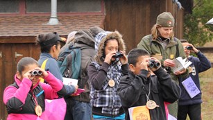 Children looking at birds through binoculars during the 2014 Christmas Bird Count for Kids.