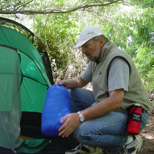 A camper setting up his tent.