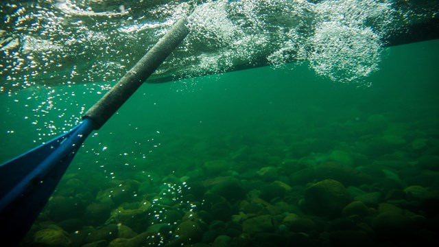 Under river shot of oar in water. 