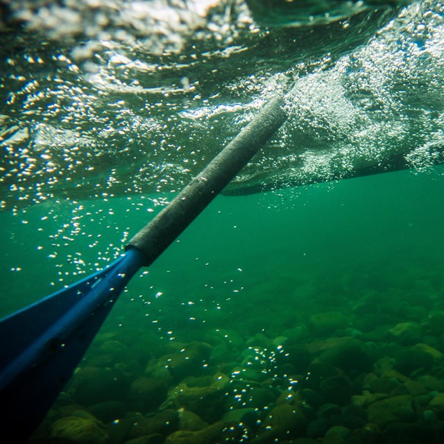 Under river shot of oar in water. 