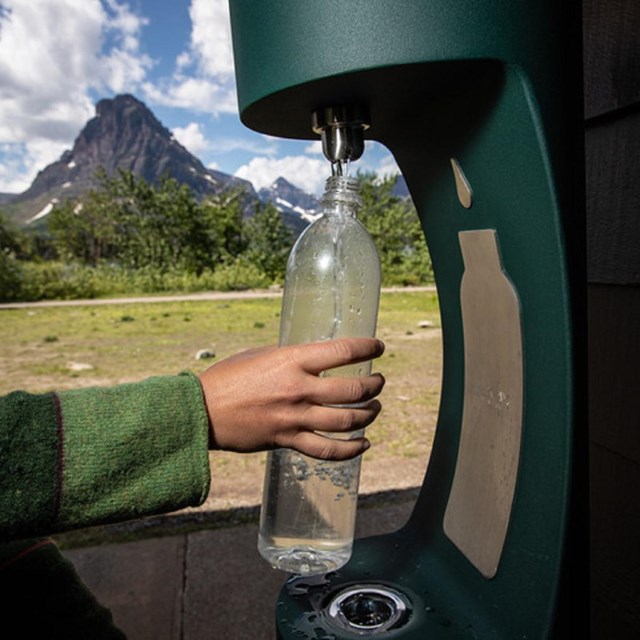 a water bottle being filled at an outdoor water bottle filling station