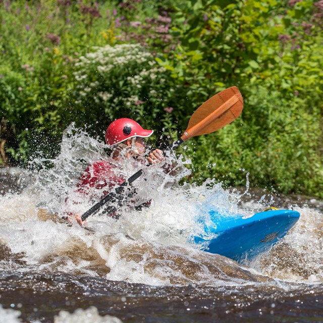 A kayak paddles through whitewater