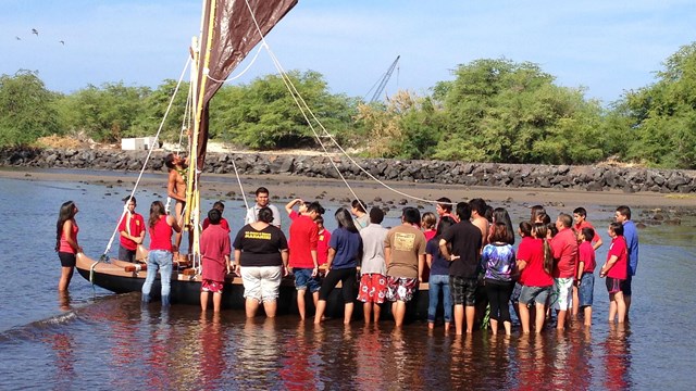 Group of kids getting a traditional canoe ready for sailing