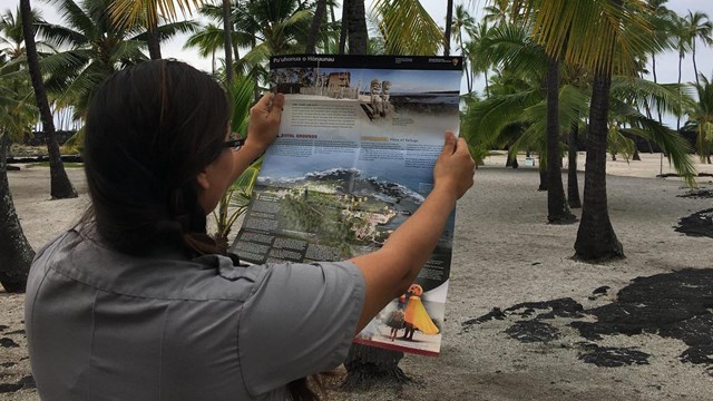 A ranger holds a map up in the Royal Grounds