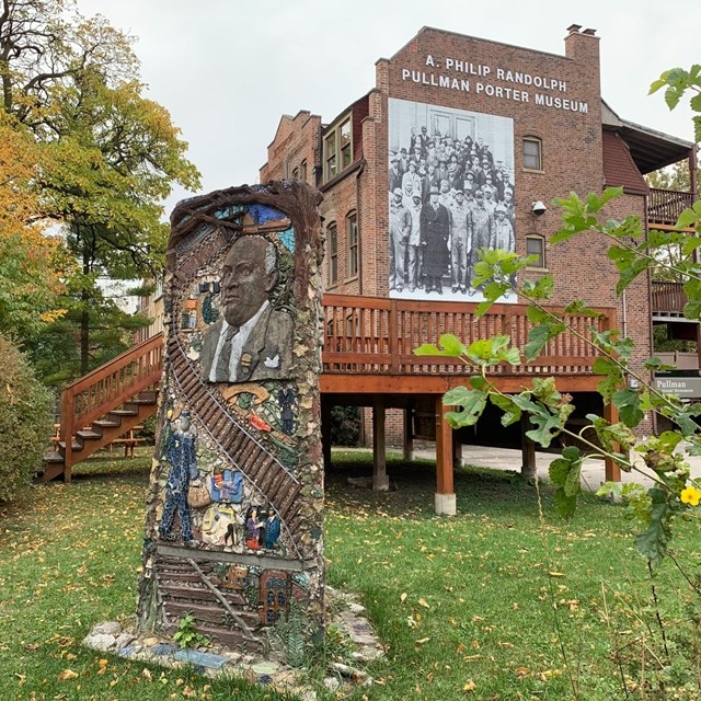 The museum entrance with statue and brotherhood blow up photo.