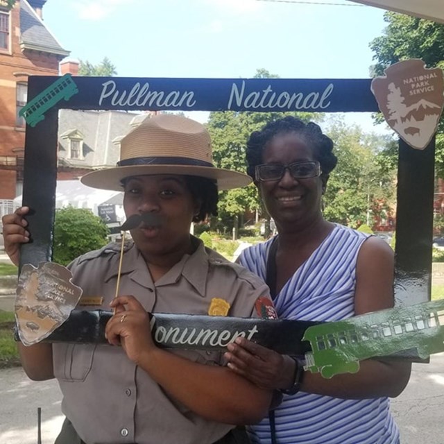 A Ranger and Visitor have fun at an event photo station.