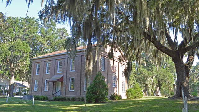 A two-story brick church with long windows on each side.