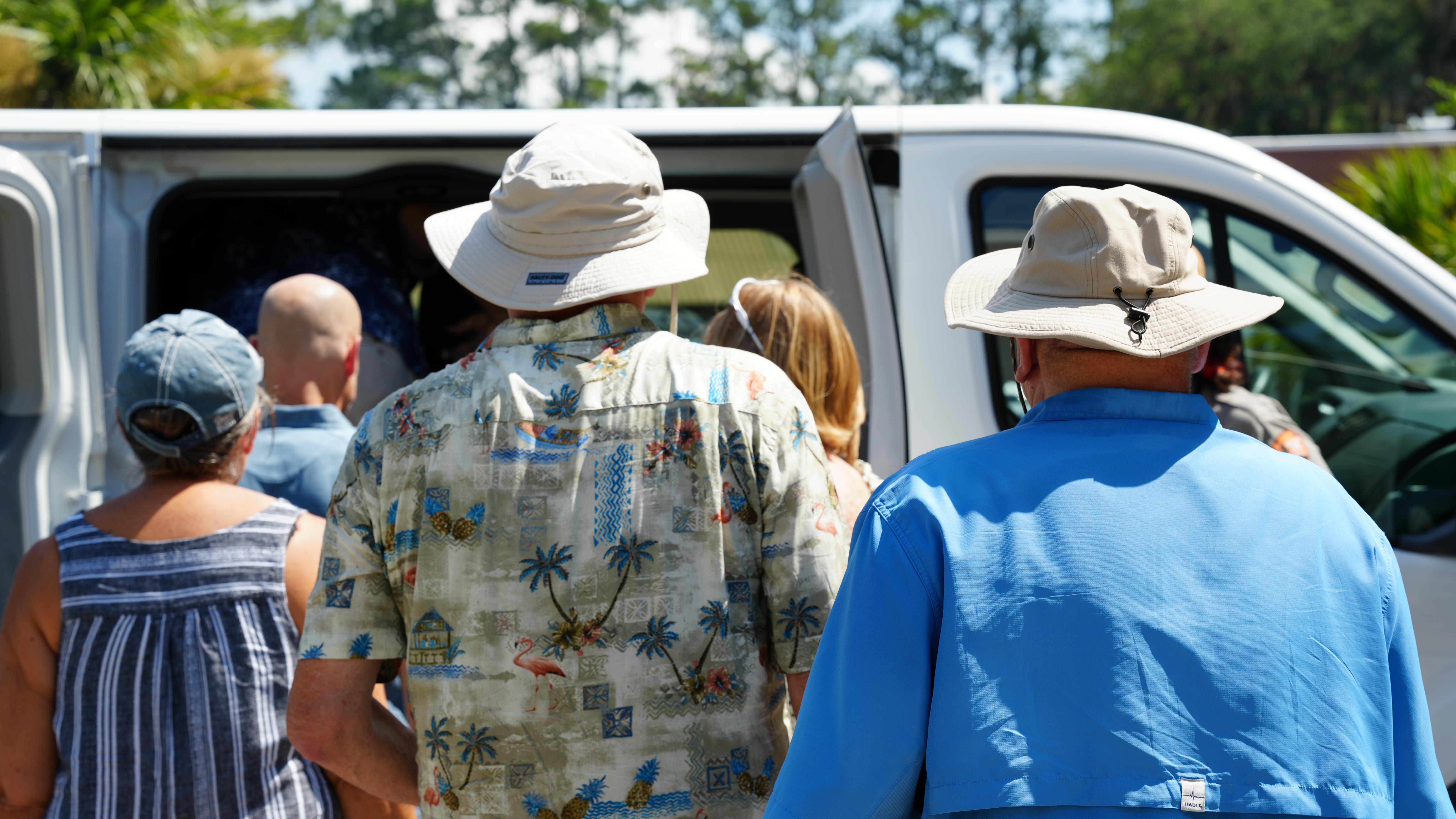 A group of people walk towards a van.