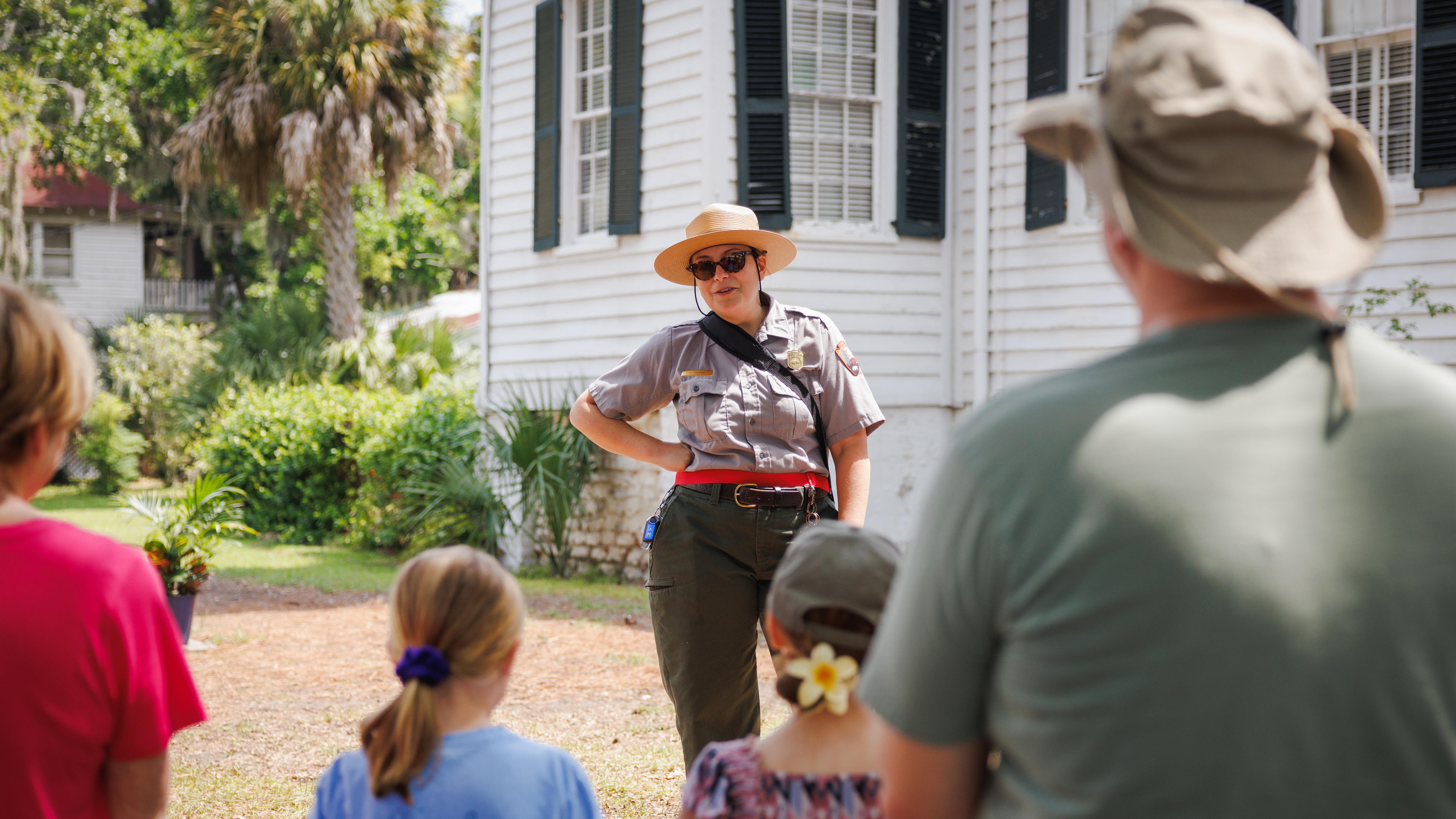 A ranger giving a tour outside to a group of people.